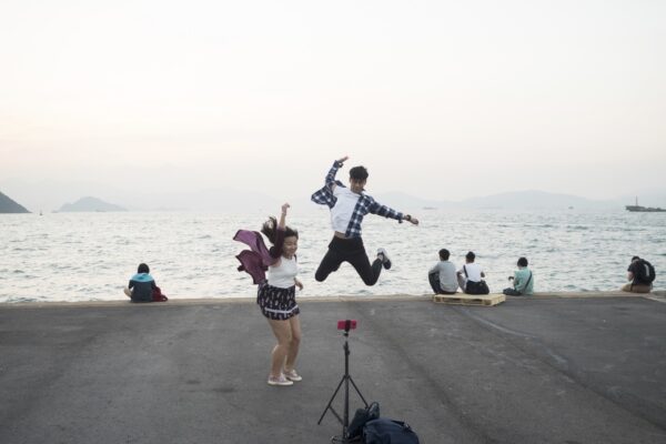 Hong Kong (Hong Kong SAR, China); Date (11, 03, 2016); A young couple practicing jumping in front of the camera; "Instagram pier" is a public cargo pier located on the west side of Hong Kong island; here locals gather for fishing, excercising or walking their pets. More recently the Pier has raised to fame as the “instagram Pier”, where young Hong Kongers and instagrammers come for selfies and scenic photos. I have recently begun curating its "instagram"  dedicated account (@insta_pier).