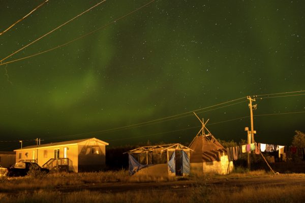 Attawapiskat, Ontario, Canada. The Northern lights, almost overpowering in their physical beauty, fill the night sky over Attawapiskat. Cree legends state that the lights are spirits of the ancestors celebrating life and showing
the living that they are all part of creation. Their dancing forms a laneway for the souls as they travel to the next realm. It is said that when Cree are living the right way and conducting ceremonies and dances, the spirits of Cree ancestors
celebrate in the heavens. Attawapiskat is an isolated First Nation community  located in northern Ontario, Canada, at the mouth of the Attawapiskat River on James Bay. On April 9, 2016, the community of approximately 2000 people declared a state of emergency after being overwhelmed with attempted suicides, over 100 attempts in a ten month period. August 27, 2016. David Maurice Smith/Oculi.